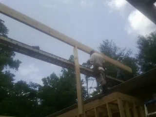 Carpenter setting a ridge beam over a new addition frame — Ice Dam Removal by Roofing Brothers in Honeyville