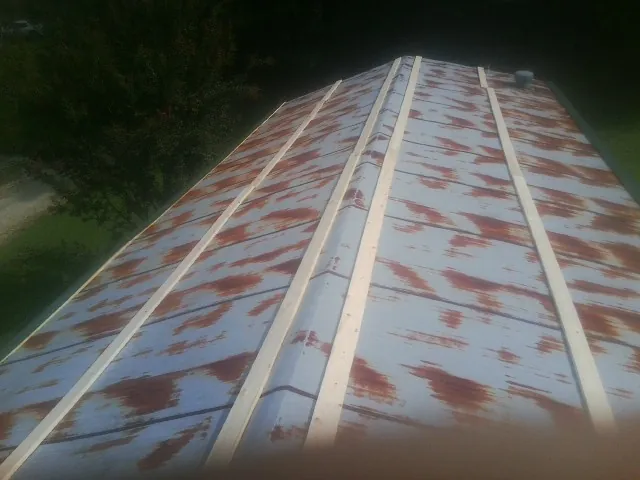 Rusted metal roof panels with new wood purlins before replacement — Storm Damage Roof Repair in Honeyville by Roofing Brothers